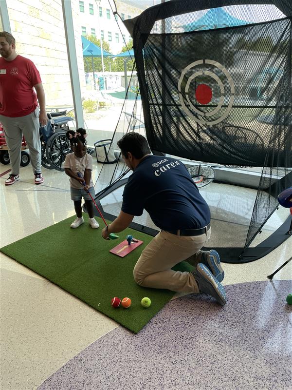 Child learning how to play golf at PGA Cares